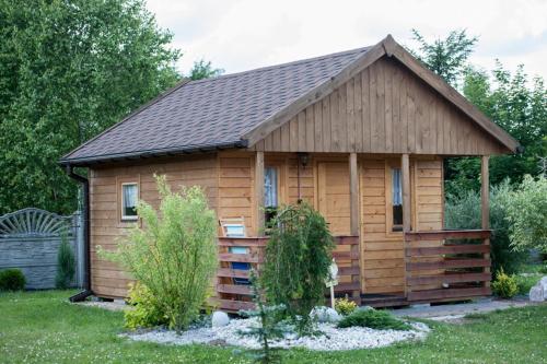 une grande cabane en bois avec un toit en gambrel dans l'établissement Domki Niegowa, à Niegowa