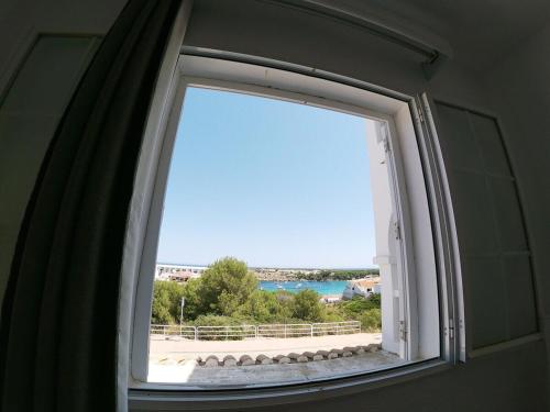 uma janela num quarto com vista para a praia em Apartamento 107 Castell Sol CB em Arenal d'en Castell