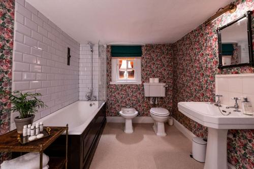 een badkamer met een bad, een toilet en een wastafel bij Martin Arms in Colston Bassett