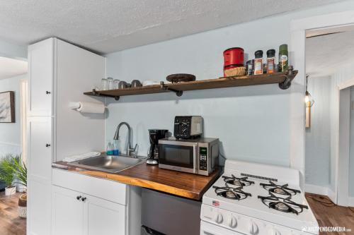 a kitchen with a white stove top oven next to a sink at Borealis Barnhouse - Slumber 7 in Anchorage