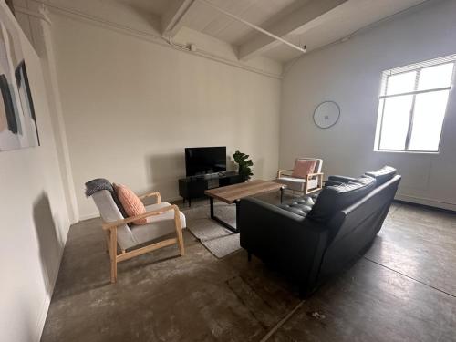 ein Wohnzimmer mit einem Sofa und einem Tisch in der Unterkunft Flexhome Westown 2BR RS3 in Fiserv and Theater District - READ INFO in Milwaukee