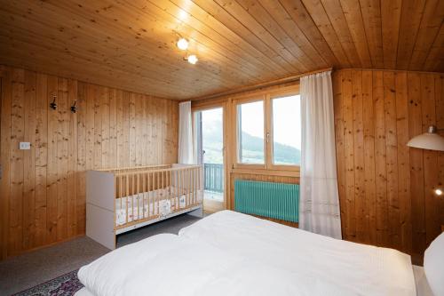 een slaapkamer met een bed en een groot raam bij Apartment im Chalet Sidonie in Amden