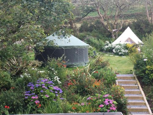 einen Pavillon inmitten eines Gartens mit Blumen in der Unterkunft Granville House Apartments in Ballyferriter