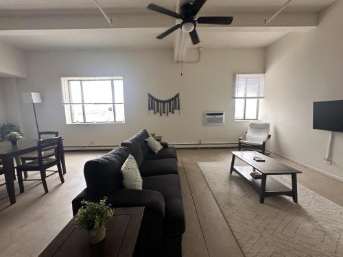 a living room with a couch and a ceiling fan at Flexhome Westown 1BR RS2 near Fiserv and Theater District - READ INFO in Milwaukee