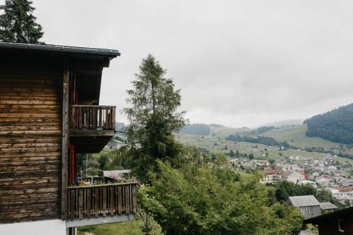 a wooden house with a balcony and a tree at Apartment im Chalet Sidonie in Amden