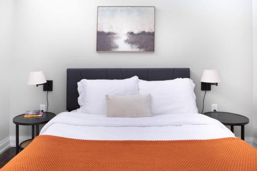 a bed with an orange blanket and two tables at Flexhome East Town 1BR MF1 - READ INFO in Milwaukee