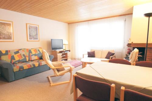 a living room with a couch and a tv at Apartment Kaiser in Amden