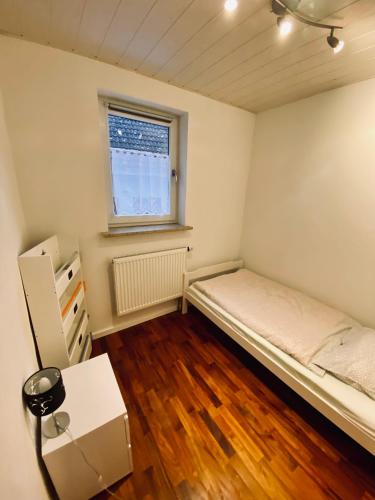 a small bedroom with a bed and a window at Ferienwohnung Antonia in Rattelsdorf