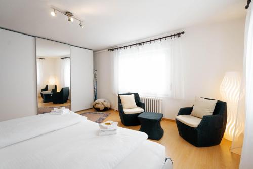 um quarto com 2 camas e cadeiras e um espelho em Apartment Raingüetli em Amden