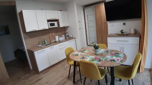 uma pequena cozinha com mesa e cadeiras num quarto em Apartament ZłotogórSKI Lądek-Zdrój em Lądek-Zdrój