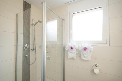 a bathroom with a shower with towels on the wall at Apartment Elona in Amden