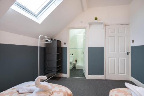 Schlafzimmer im Dachgeschoss mit weißer Tür und Bad in der Unterkunft 4Bedrooms-3Bath-9Beds-Wallsend in Old Walker
