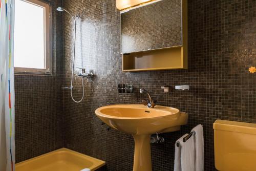 uma casa de banho com um lavatório e um chuveiro em Chalet Theresia em Amden