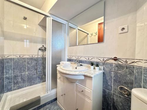 a bathroom with a sink and a shower and a mirror at Apartamento de diseño en el puerto de Castro in Castro-Urdiales