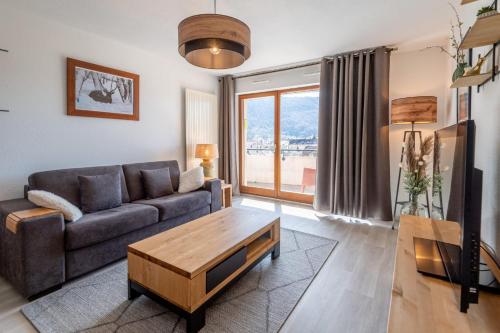 uma sala de estar com um sofá e uma mesa de centro em DUCS DE SAVOIE - Comfortable flat a stone's throw from the old town em Annecy