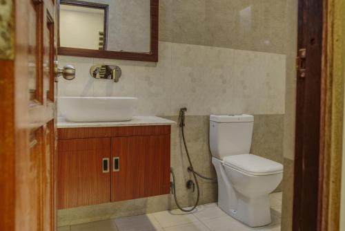 W łazience znajduje się toaleta, umywalka i lustro. w obiekcie Manta Sky Inn w mieście Dharavandhoo