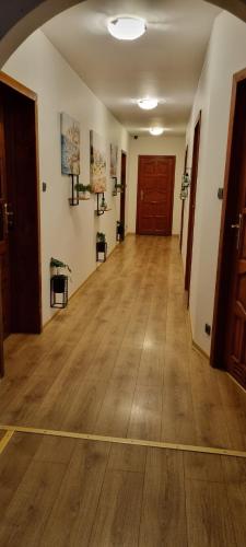 an empty hallway with a wooden floor and a door at Noclegi na Łącznej in Świebodzice