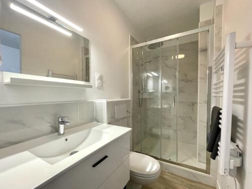 a white bathroom with a sink and a shower at Le repère secret de Nestor - SOnights in Château-du-Loir
