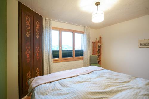Schlafzimmer mit einem Bett und einem Fenster in der Unterkunft Chalet Fridolin in Amden