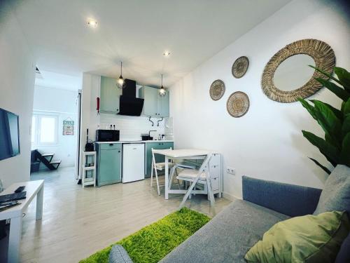 un salon avec un canapé et une table et une cuisine dans l'établissement Just Sezimbra, à Sesimbra