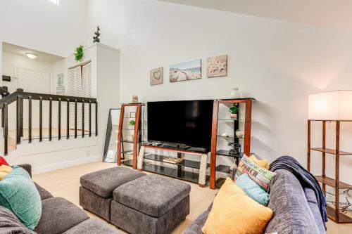 a living room with a couch and a flat screen tv at West Palm Beach Lake House Near Beaches! in West Palm Beach