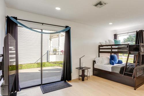 a bedroom with a bunk bed and a sliding glass door at West Palm Beach Lake House Near Beaches! in West Palm Beach