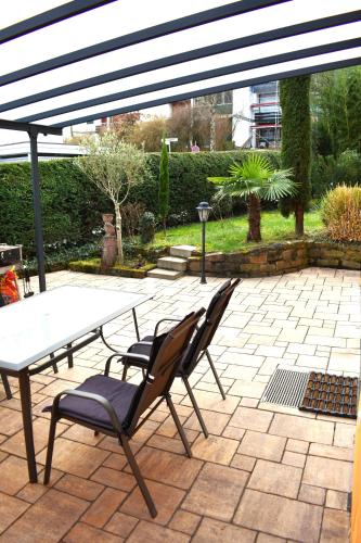 a patio with a table and two chairs under a pergola at FVH Family Vacation Heidelberg in Heidelberg