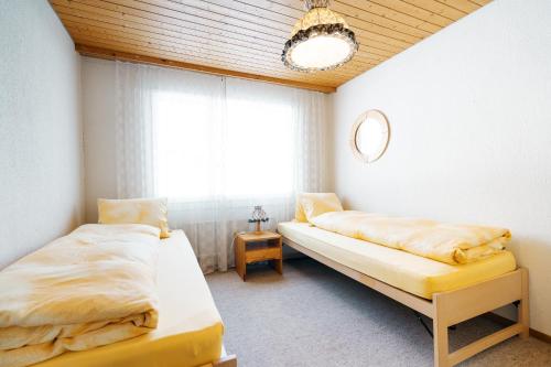 1 Schlafzimmer mit 2 Betten und einem Fenster in der Unterkunft Apartment Bischofberger D22 in Amden