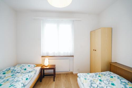 - une chambre avec 2 lits et une fenêtre dans l'établissement Apartment Im Aeschen, à Amden