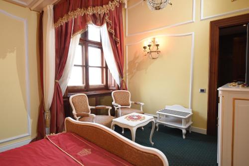 
a room with a bed, chair and a window at Hotel Leopold I in Novi Sad
