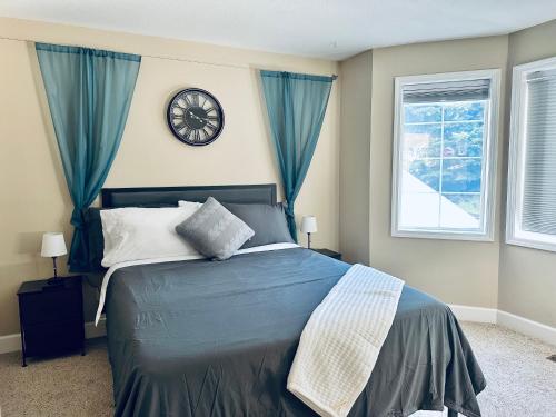 1 dormitorio con 1 cama con reloj en la pared en Sopra Bella- 4 bedroom home, en Corvallis
