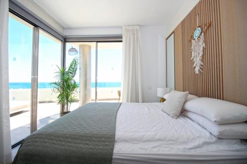 a bedroom with a bed with a view of the beach at Apartment Aria By The Beach in Los Pulpites