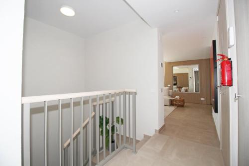 a hallway with a staircase with a fire extinguisher at Apartment Aria By The Beach in Los Pulpites