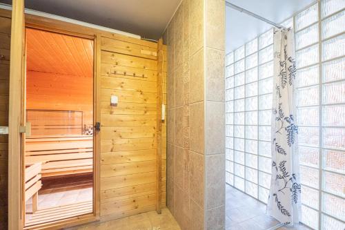 a bathroom with a shower and a wooden door at Willa Zacisze - Pokoje Gościnne in Wrocław