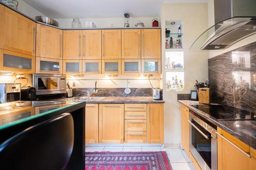 a kitchen with wooden cabinets and a red rug at Willa Zacisze - Pokoje Gościnne in Wrocław