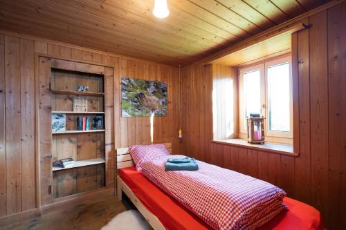 a bedroom with a bed in a wooden room at Cottage Obereichholzberg in Weesen
