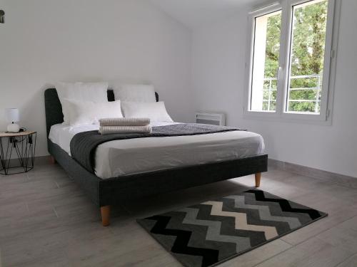 un lit dans une chambre blanche avec une fenêtre dans l'établissement Maison climatisée 3 chambres au coeur des vignobles bordeaux Léognan, à Léognan