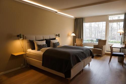 een slaapkamer met een groot bed en een raam bij Frederiksdal Sinatur Hotel & Konference in Kongens Lyngby