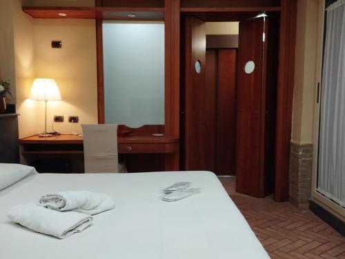 una camera da letto con un letto e asciugamani di Hotel Suite Ares a Napoli