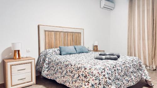 Un dormitorio con una cama con almohadas azules. en La Cala del Moral 45 en Ayamonte