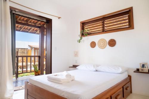 a bedroom with a bed and a large window at Pousada Meu Lugar in Jericoacoara
