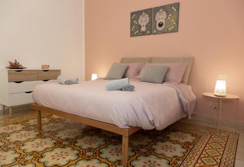 um quarto com uma cama grande com almofadas rosa em La Casa di Aurora em Trapani