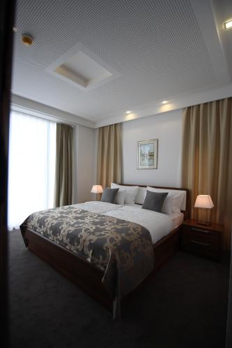 a bedroom with a large bed and a large window at Hotel Royal Gold City - Hotel Ruža in Sarajevo