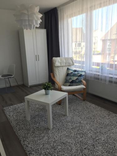 ein Wohnzimmer mit einem Stuhl und einem Couchtisch in der Unterkunft Appartement Ratingen Tiefenbroich in Ratingen