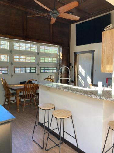 uma cozinha com um bar com bancos e uma mesa em All Seasons Treehouse Village em Eureka Springs
