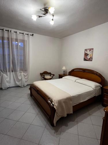 1 dormitorio con 1 cama y ventilador de techo en Tasinanta casa vacanze, en Santa Luria
