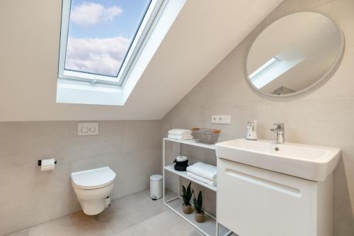 a bathroom with a toilet sink and a window at Apartment Milse - Modern. Stylisch in Bielefeld