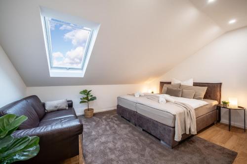 a bedroom with a bed and a couch and a window at Apartment Milse - Modern. Stylisch in Bielefeld
