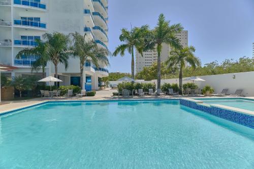 a large swimming pool in front of a building at Elegante Aqua Marine Apartamento Juan Dolio in Juan Dolio