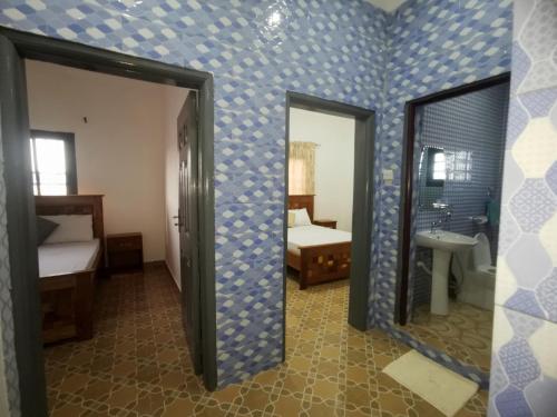 een kamer met blauwe muren met een spiegel en een slaapkamer bij BARAKAH ESTATE APARTMENTS in Sere Kunda